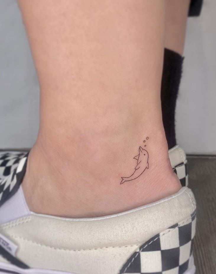 Continuous line dolphin tattoo on the left inner arm.